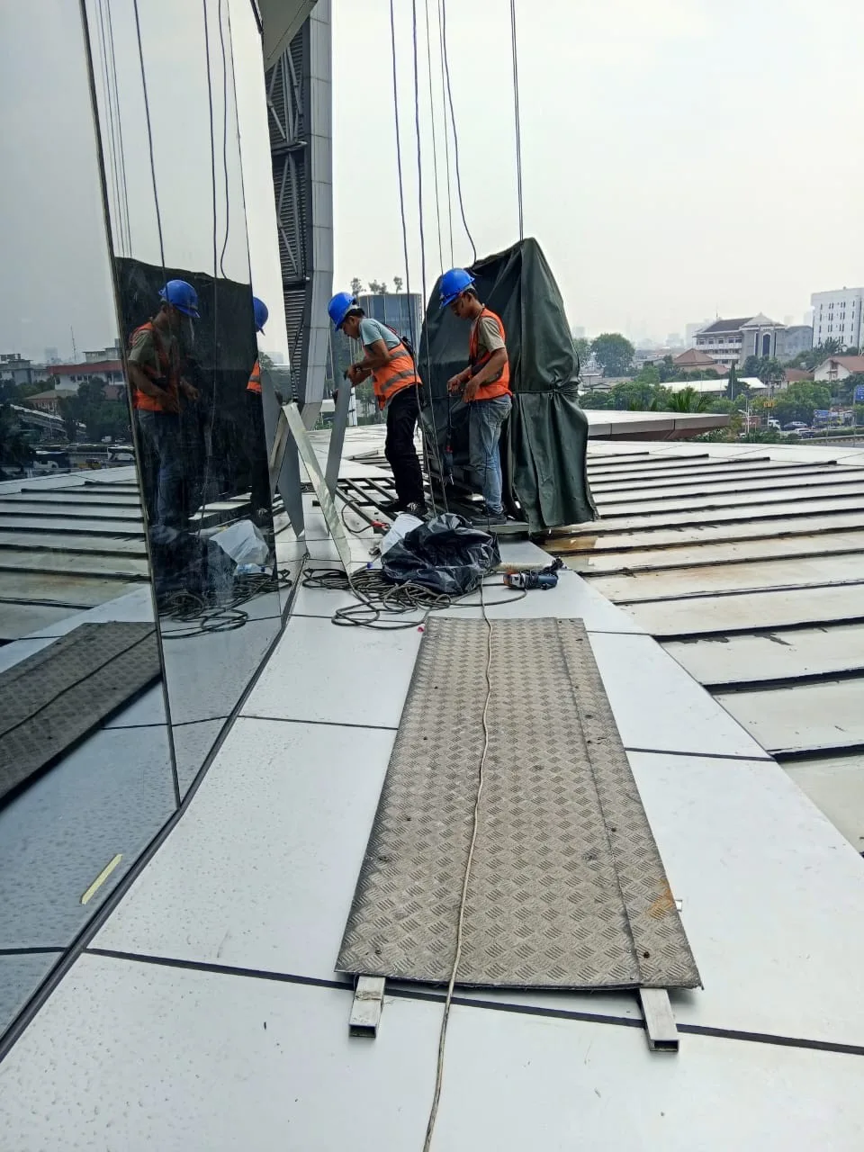 Teknisi Partindo bekerja pada sistem kaca di ketinggian
